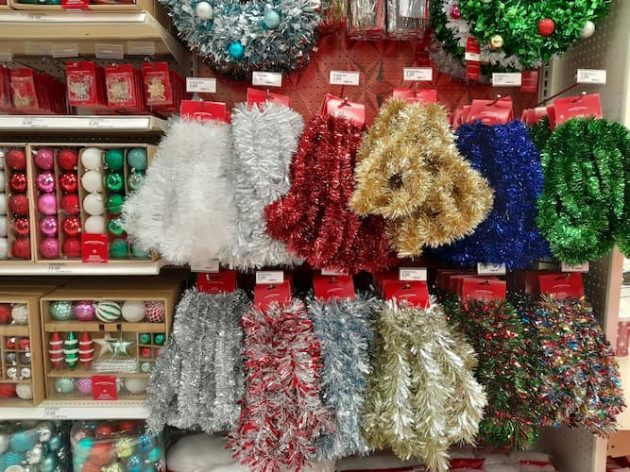A store displays shelves of colorful bulb ornaments and tinsel.
